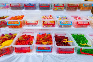 Bit pazarında satılık çeşitli renkli şeker ve tatlılar tepsilere konur..