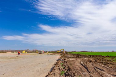 Peyzaj, makinelerle kentsel alana dönüşüyor, insanlar çalışıyor. İnşaat alanında görüntüle.