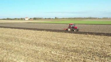 Dolly, tarlada toprağı sürerken traktörü geriye doğru hareket ettiriyor. Gelecek sezon ekin ekimi için toprağı hazırlıyor..