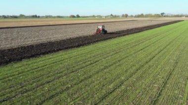 Dolly 'nin hareketli traktörün tarlayı sürdüğü, ekili tarlaları sürdüğü, toprağı gelecek sezon ekime hazırlayan alçak görüş alanı..