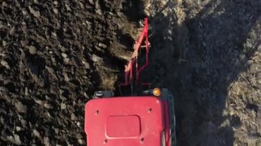 Çekicinin dolly hareketli çekimde hava üst görüntüsü ekili tarım tarlasında toprağı sürerken, toprağı yeni ekin ekimi için hazırlarken gelecek sezon.