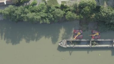 Nehir, kanal, derinleştirme ve kirli bir su yolundaki tortu, çamur, nehir yatağından kaldırma üzerinde çalışan iki kazıcının üzerinde tepenin üstündeler. 30fps DLog-M H.265 10 Bit Renkli