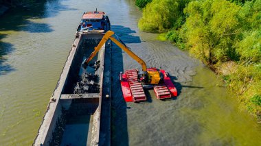 Kazı makinesinin üzerinde derinlemesine tarama, nehir, kanal, tortuları derinleştirme ve kaldırma, kirli bir su yolundaki çamur. 