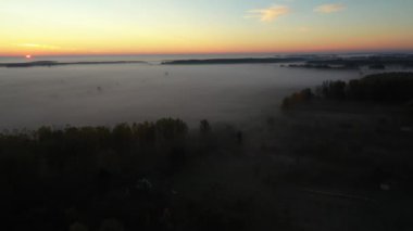 Kamera ileri gidiyor, yukarıda yavaşça yüzen buhar, ormanın üstünde buhar, şafak vaktindeki manzara güneş ufkunu göstermeden önce, doli hareket etmeden önce..