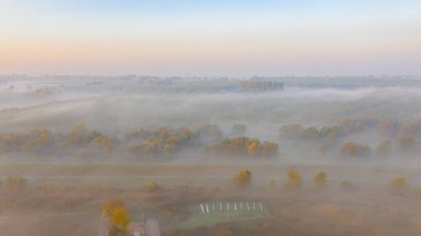 Sabahın erken saatlerindeki sislerin havadan görünüşü, yavaşça süzülen buhar, şafak vakti ekilmiş bitki örtüsünün üzerinde buhar..