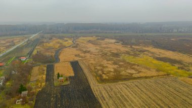 Çamurlu bir günde, yeşil manzaranın üstünde, birkaç ekili, ekilebilir arazi..