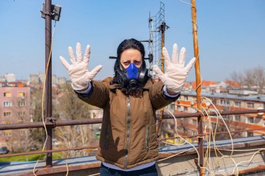 Medya baskısını durdurun. Endüstriyel maske takan kadının yüzünde kağıt filtre var. Elleri, hareketi, sosyal mesafesi, uzak durması, COVID-19 virüsüne karşı korunması, Corona.