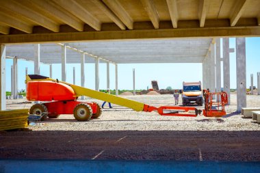 İnşaat alanındaki park halindeki vişne toplayıcısına bak.