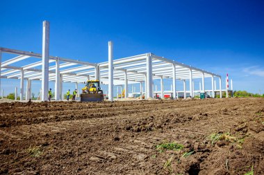 Büyük kazıcı inşaat alanında toprak çıkarıyor. Proje devam ediyor..