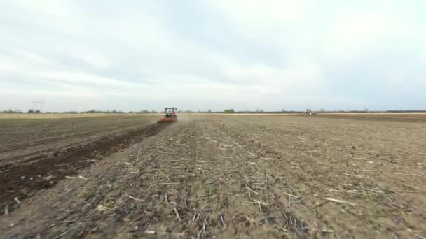 牽引機としてトラクターのドリー移動ショットでビューの低い場所は 次の季節に新しい作物を植えるための土壌を準備し 耕地を耕す — ストック動画