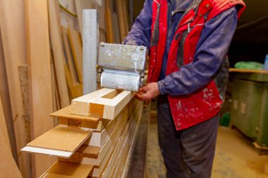 Marangozluk işçisi, ahşap yüzey profillerine yapıştırıcı uygulamak için kullanışlı paten aracı kullanıyor..