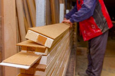 Marangozluk işçisi atölyede ahşap profilleri yapıştırmayı ayarladı ve onları kıskacı sıkıştırmak için hazırladı. Elle işlemedeki kurutma tutkalı süreci.