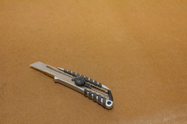 Marangozluk atölyesindeki kontrplak üzerine açık bıçaklı neşter..