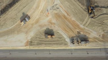 Üst görünümde, bıçağın seviyelendirme makinesinin üstünde, derece, yeni dairesel yol için küçük ezilmiş taş seviyelendirme katmanı, patenci sıkıştırma toprağı, yapım aşamasında döner kavşak, yol temeli.