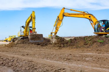 İki büyük kazıcı inşaat alanındaki toprak katmanını kaldırıyor, proje devam ediyor.