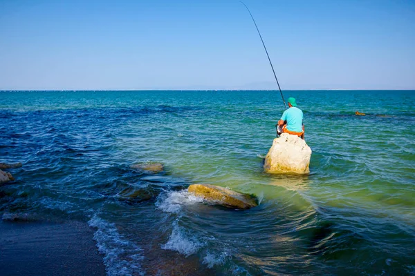 Tânăr Adult Stă Stâncă Apa Mare Mică Adâncime Pescuieşte — Fotografie, imagine de stoc