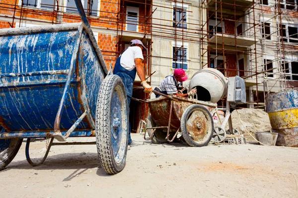 Workers Pour Mortar Wheelbarrow Attached Crane Hooks Carry Transport — Stock Photo, Image