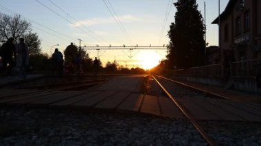 Yolcu treni tren istasyonuna vardı, insanlar aceleyle yürüyordu, güneş arka plandaydı. Siluet, insanların gölgeleri, yolcular, banliyö yolcuları iş hayatında trenden iniyorlar, yoğun yaşam tarzı ulaşımı.