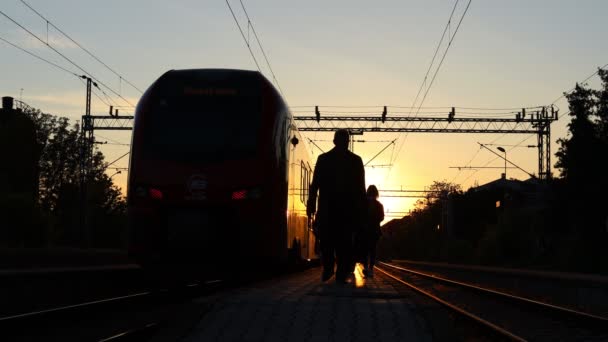 旅客列車の鉄道プラットフォーム駅に到着し 人々は急いで バックライトで日歩いている シルエット 人の影 通勤者は ビジネスで電車から出ています忙しいライフスタイル輸送 — ストック動画