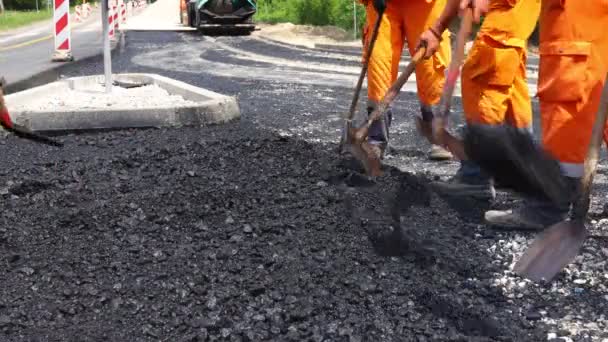 工人们很少用铲子铲平 铺好一层新的跑道 浇上热沥青 — 图库视频影像