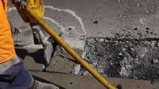 建筑工人用气动钻砸碎沥青 男人用铲子捡起并扔掉破碎的零件 — 图库视频影像