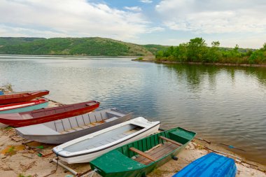 Boyalı tekneler betonla kaplı kıyı şeridine yanaşmış..