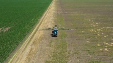 Dolly 'nin üstündeki kamera traktörü takip ediyor. Ta ki bitmeyen tarlaları püskürterek ekili bir tarlaya yayılmış tarımsal püskürtücüleri sürükleyene kadar..