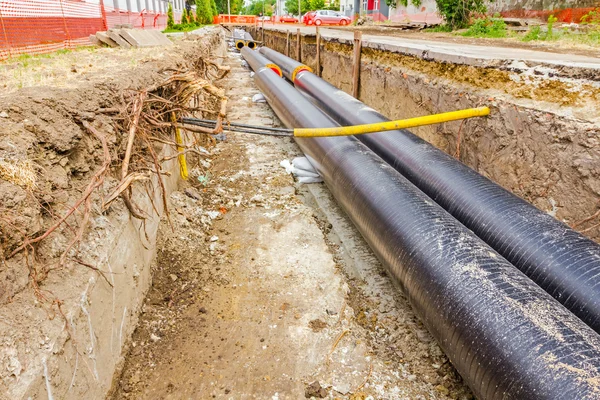 Neu verlegte Rohre in einem frischen Graben. Unfertige Pipeline — Stockfoto