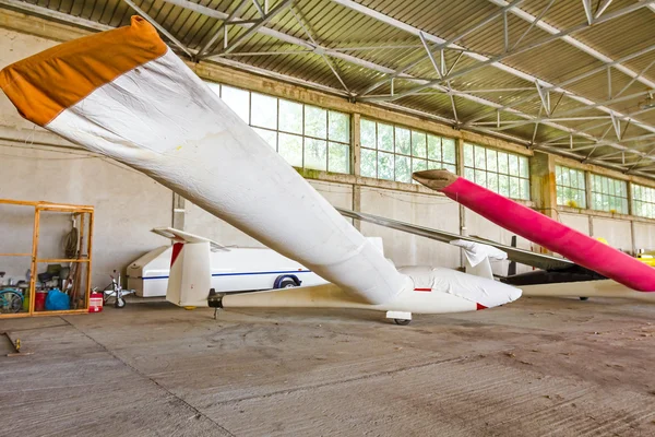 Lightweight gliders stationed inside of a big hangar — Stock Photo, Image