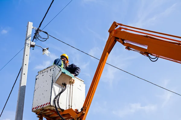 Équipe de lignes électriques au travail sur un poteau — Photo