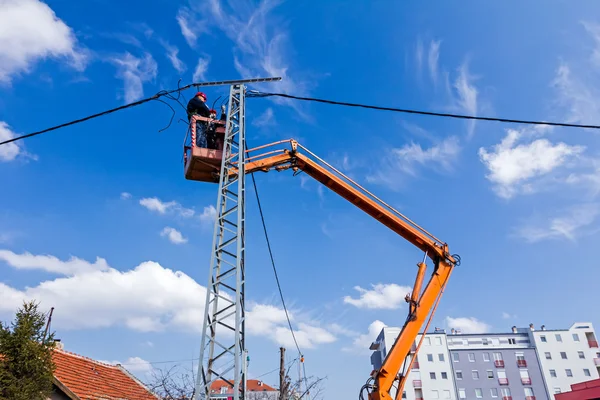 Team di linee elettriche al lavoro su un palo — Foto Stock