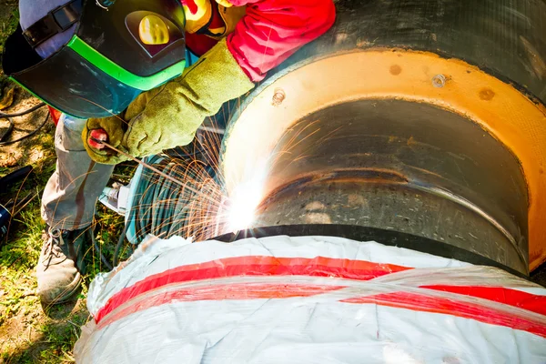 Soldador de tiro de cerca hasta la soldadura, chispas volando alrededor . — Foto de Stock