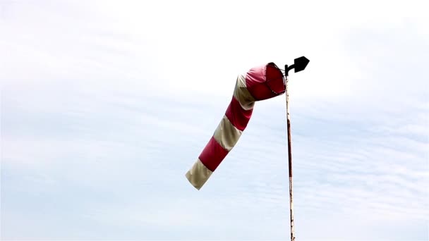Vermelho e branco windsock sopra contra um céu azul — Vídeo de Stock