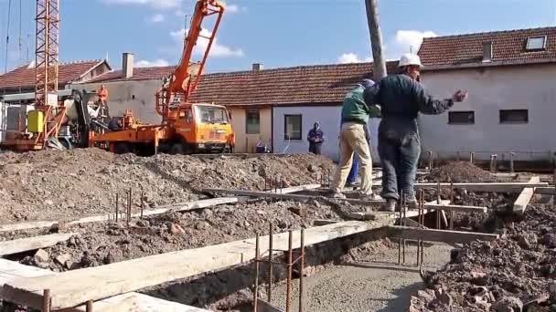 建設作業員のチームが建設現場でコンクリートに取り組んでいます。. — ストック動画