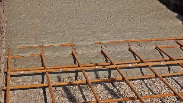 O concreto está se espalhando na fundação sobre o reforço de barras de aço . — Vídeo de Stock