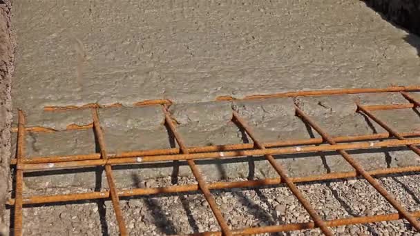 Le béton se répand dans les fondations sur les barres d'armature en acier . — Video