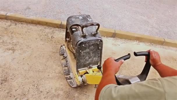 La compactación del suelo está en el sitio de construcción en la calle de la ciudad . — Vídeo de stock