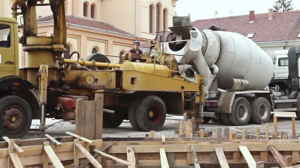 Beton pumpt zwischen Lastwagen zum Fundament.