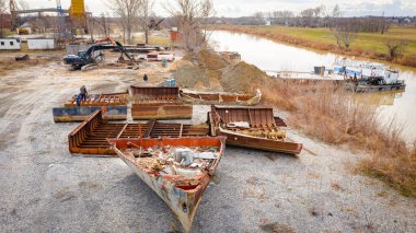 Above view on workers as they cutting parts of old large vessel into smaller pieces, barge, dismantling ship, cut out rusty metal for scarp, using acetylene torch, recycling, sparks are fly around.