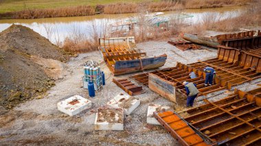 Above view on workers as they cutting parts of old large vessel into smaller pieces, barge, dismantling ship, cut out rusty metal for scarp, using acetylene torch, recycling, sparks are fly around.