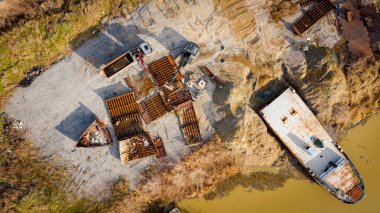 Above view on excavator and tow grapple truck with hydraulic grappling claw, multivalve grab hand, gripper machine, manipulator, loading part of vessel into container, collect rusty metal, recycling.