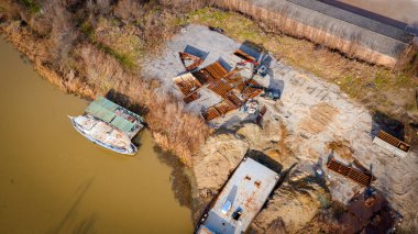 Above view on excavator and tow grapple truck with hydraulic grappling claw, multivalve grab hand, gripper machine, manipulator, loading part of vessel into container, collect rusty metal, recycling.