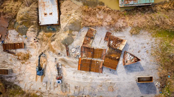 Above top view on workers as they cutting parts of old large vessel into smaller pieces, barge, dismantling ship, cut out rusty metal for scarp, using acetylene torch, recycling, sparks are fly around.