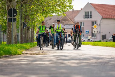 Zrenjanin, Voyvodina, Sırbistan - 26 Nisan 2025: Bisiklet süren, bisiklete binen, şehirde bisiklete binen bir grup genç, trafikteki ve kentsel çevredeki bisikletçilere yönelik tehlikelere dikkat çekmek için düdük çalıyor. 