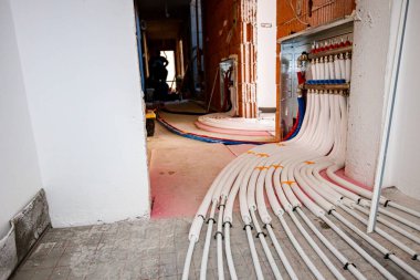 New brass distribution system manifold valves are mounted for central heating floor in a residential building under construction.