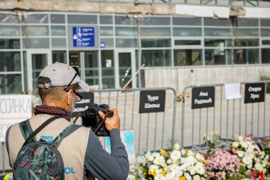 Novi Sad, Sırbistan 11. 01.2025 Fotoğrafçı, tren istasyonunda tepe örtüsünün çöktüğü trajik kazada hayatını kaybeden 16 kişi için anma toplantısında fotoğraf çekiyor.