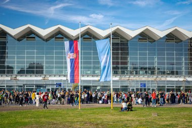 Novi Sad, Sırbistan 11.01.2025: Trajik kaza yeri olan tren istasyonunun önünde ulusal bayrak yarıya indirildi. Tepe örtüsü çöktü ve 16 kişiyi öldürdü. Kaybedilen hayatlar için yas ve keder eylemi.