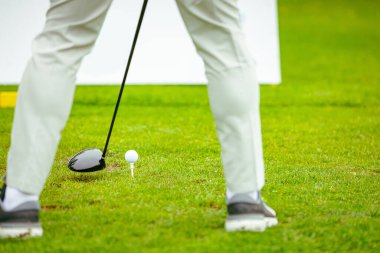 Golfçüye alçak açı vuruşu, güçlü golf topu vuruşu, golf vuruşuna başlamadan hemen önce. Golf sahasında golf sopası ile atış yaptı..