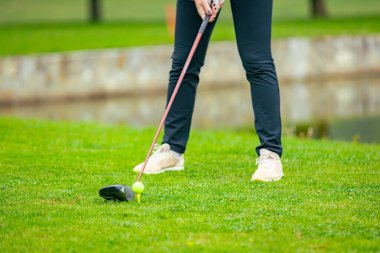Golfçüye alçak açı vuruşu, güçlü golf topu vuruşu, golf vuruşuna başlamadan hemen önce. Golf sahasında golf sopası ile atış yaptı..