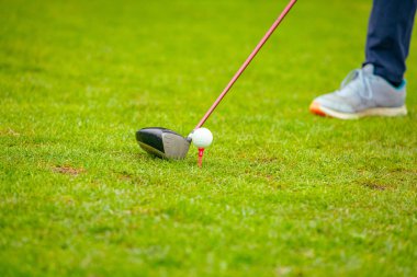 Golfçüye alçak açı vuruşu, güçlü golf topu vuruşu, golf vuruşuna başlamadan hemen önce. Golf sahasında golf sopası ile atış yaptı..